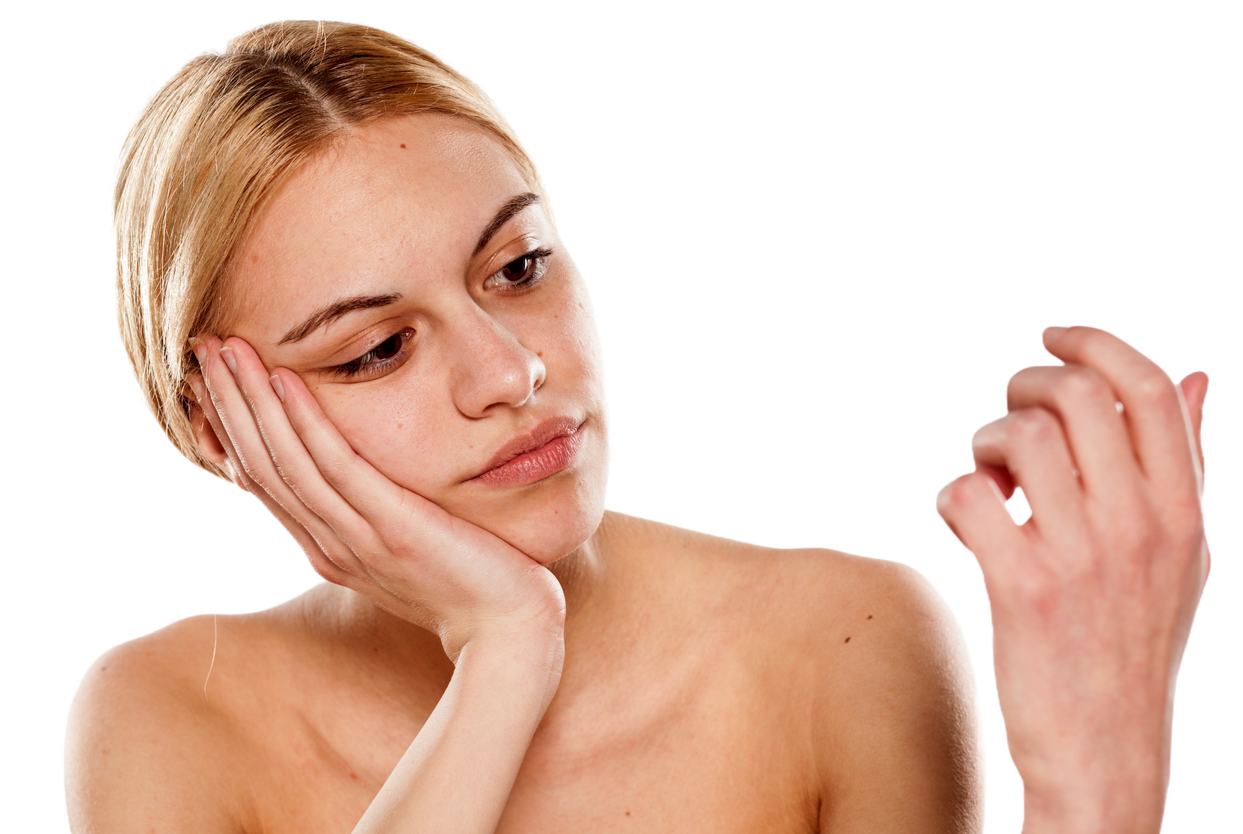young blonde woman inspecting her nails for nail fungus